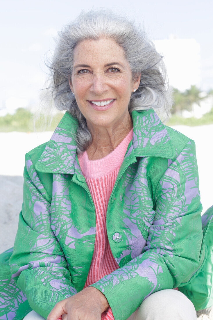 Gray-haired woman in a green coat