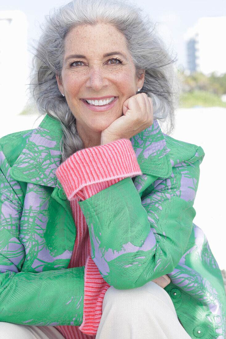 Gray-haired woman in a green coat