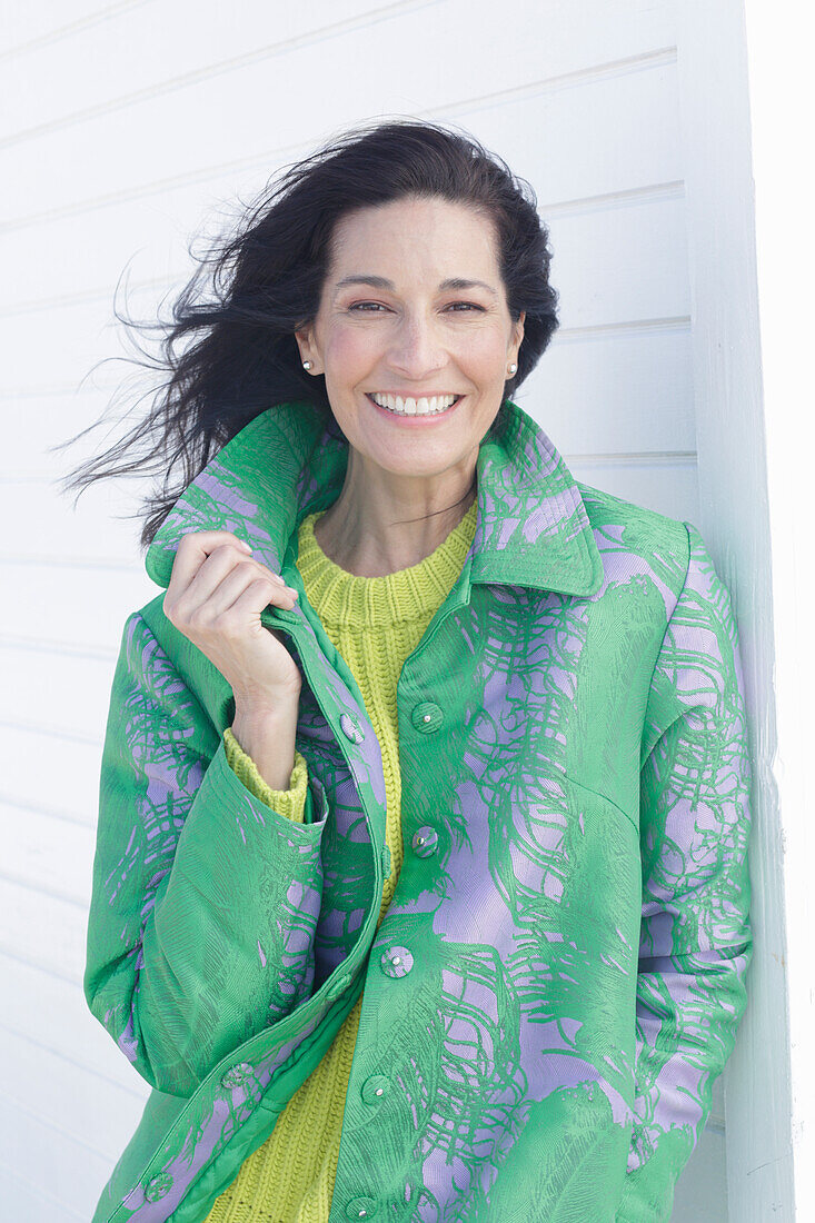 Mature, dark-haired woman in a green coat