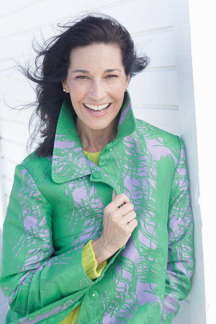 Mature, dark-haired woman in a green coat