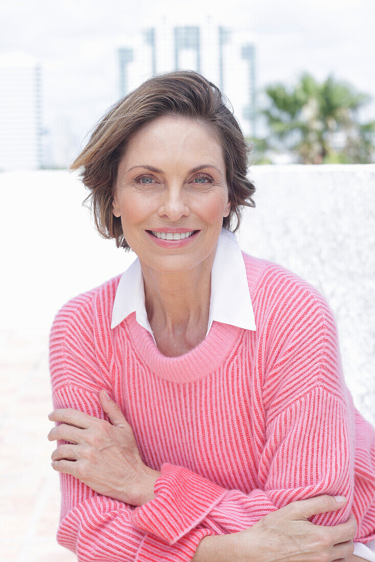 Woman in a pink sweater and white shirt on the beach