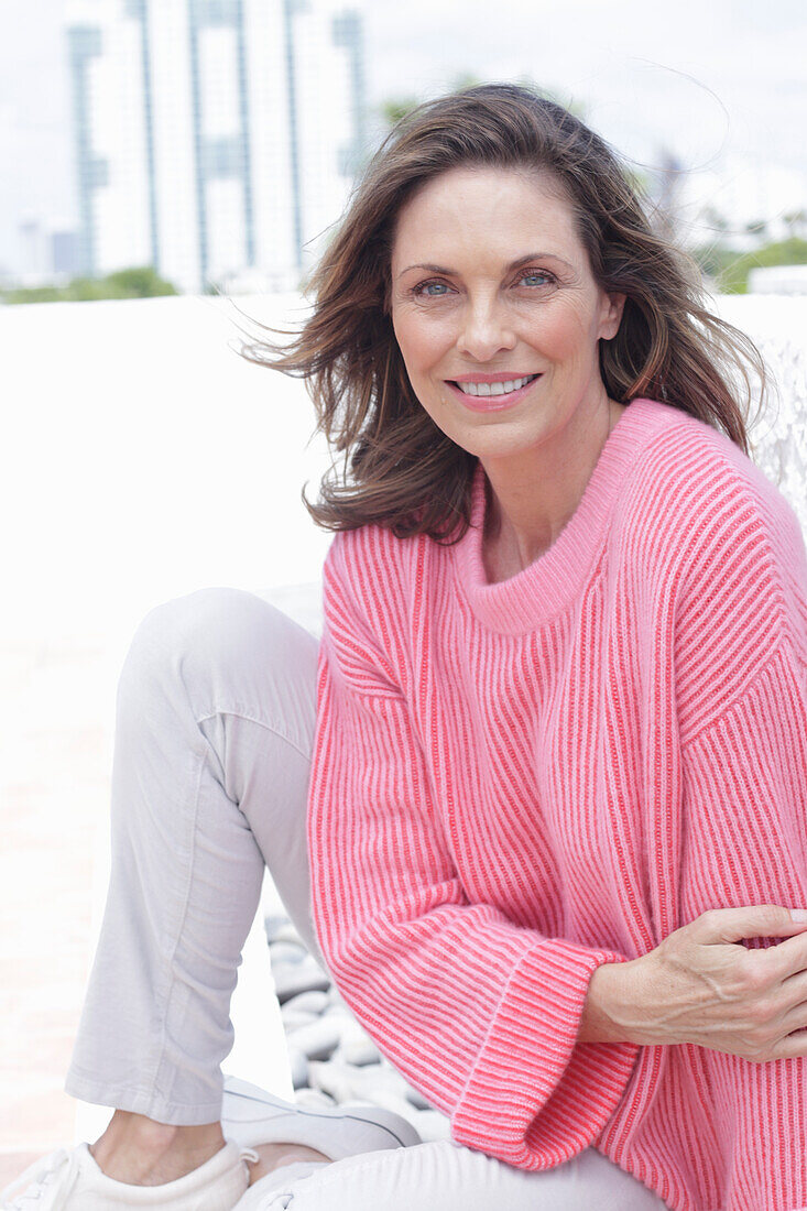 Woman in pink sweater and white pants