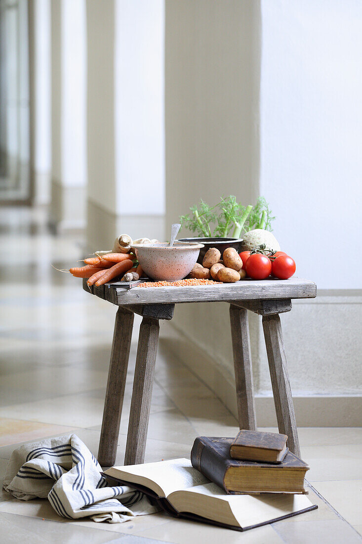 Old books and ingredients for fasting soup on a wooden stool