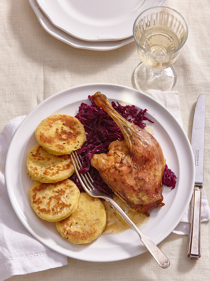 Duck with braised red cabbage and small potato pancakes