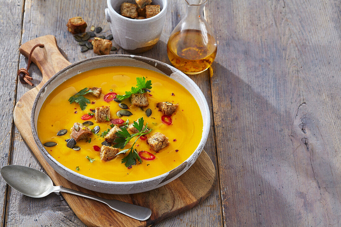 Pumpkin soup with croutons, pumpkin seeds and chili