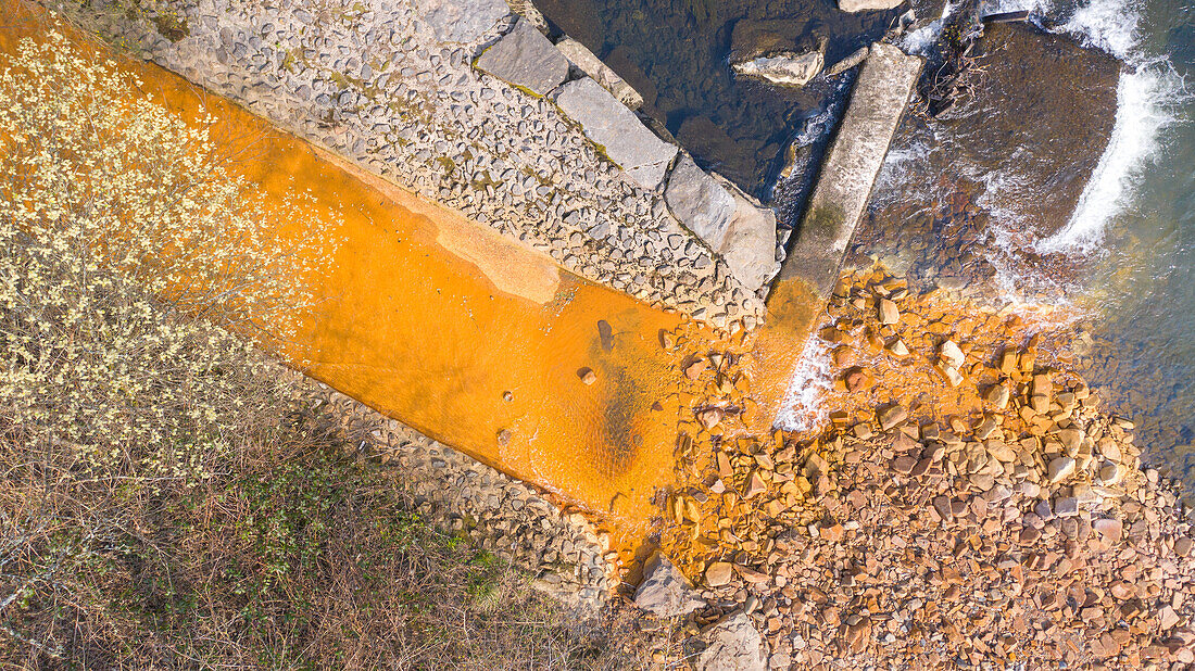Orange iron oxide staining in stream, aerial photograph