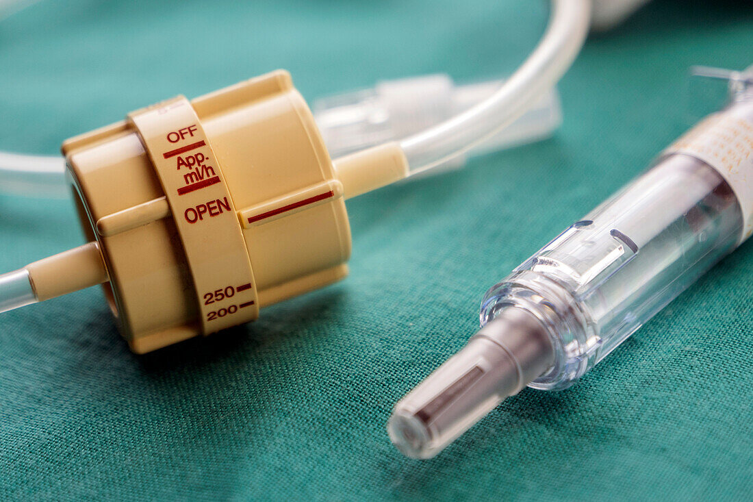 Dial flow next to a syringe at a hospital table