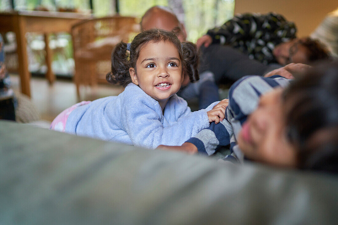Happy toddler girl with family on sofa