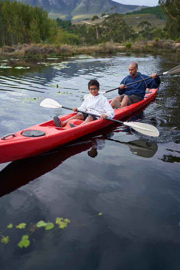 Father and son kayaking on river