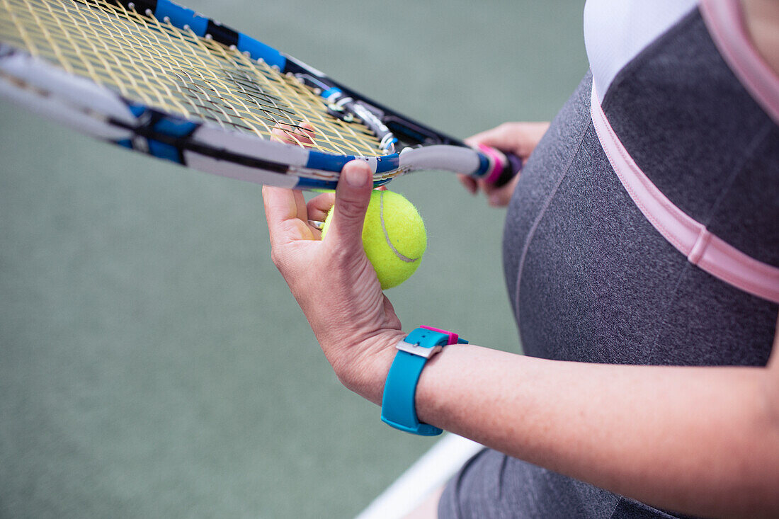 Close up pregnant woman with tennis racket and ball