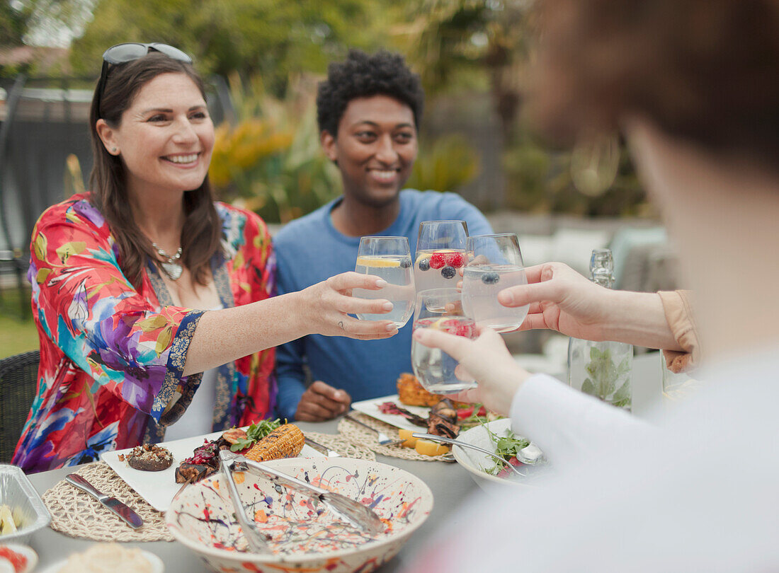 Happy couples toasting glasses at patio lunch