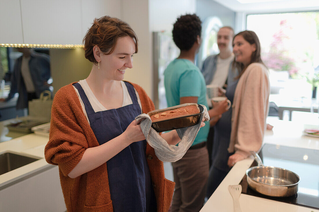 Happy woman baking loaf cake in kitchen