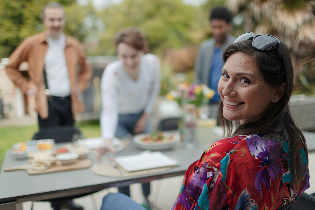 Happy woman enjoying lunch with friends at patio table