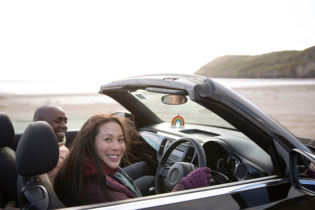 Happy couple in convertible on winter beach