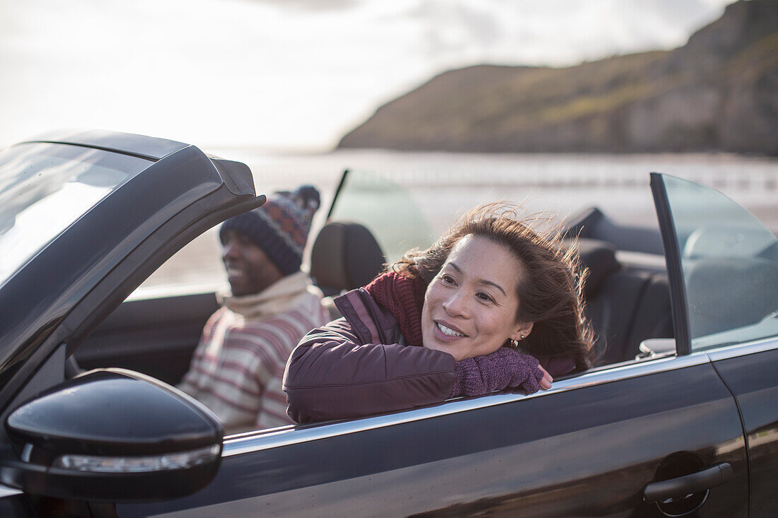 Happy woman in convertible on beach