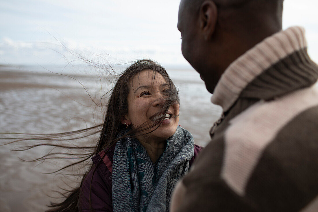 Happy couple on windy winter beach