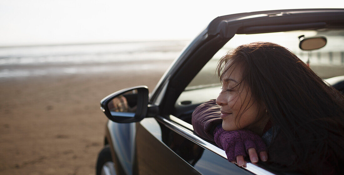 Woman in convertible on beach