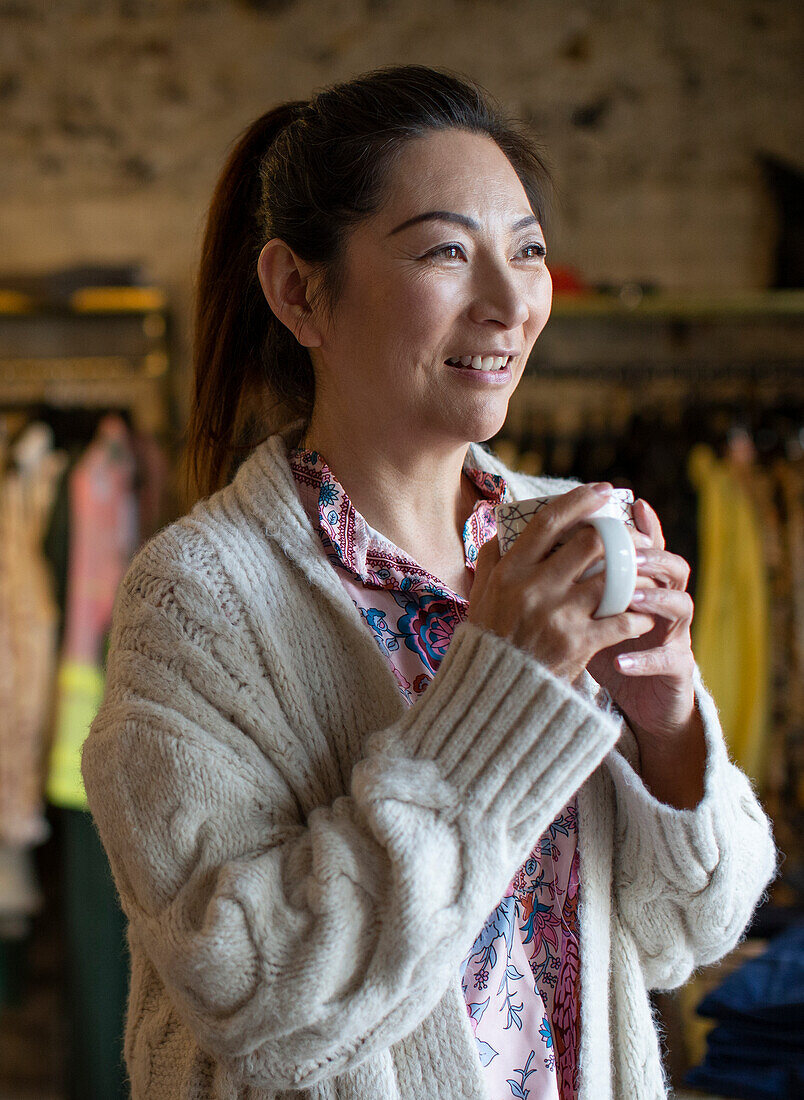 Happy woman drinking coffee in shop