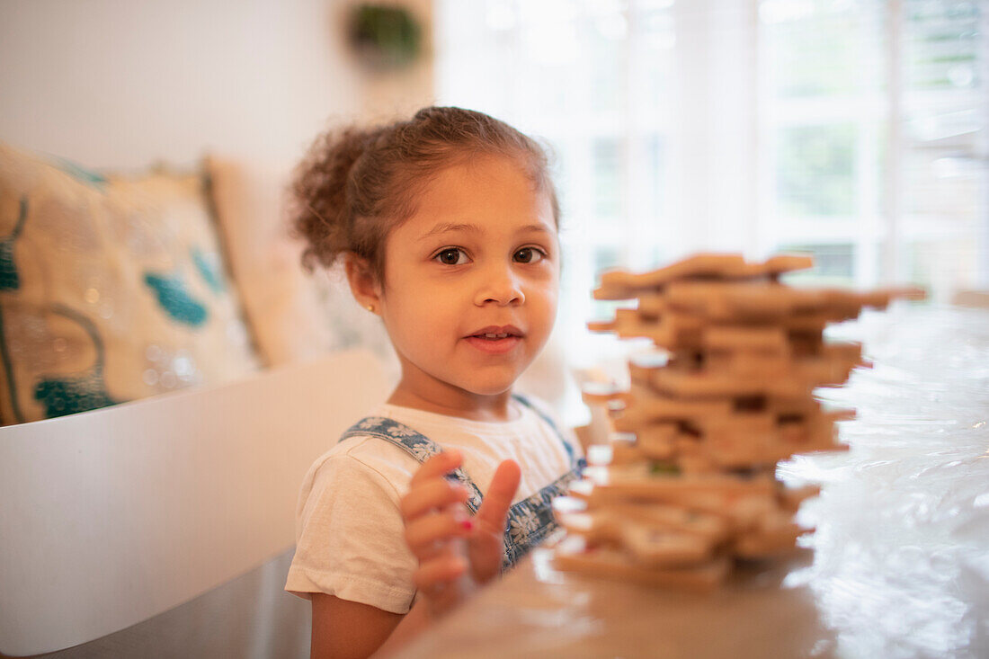 Girl playing with wood puzzle pieces