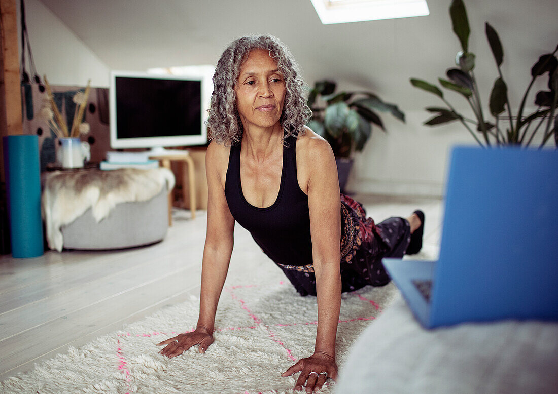 Woman practicing yoga at laptop