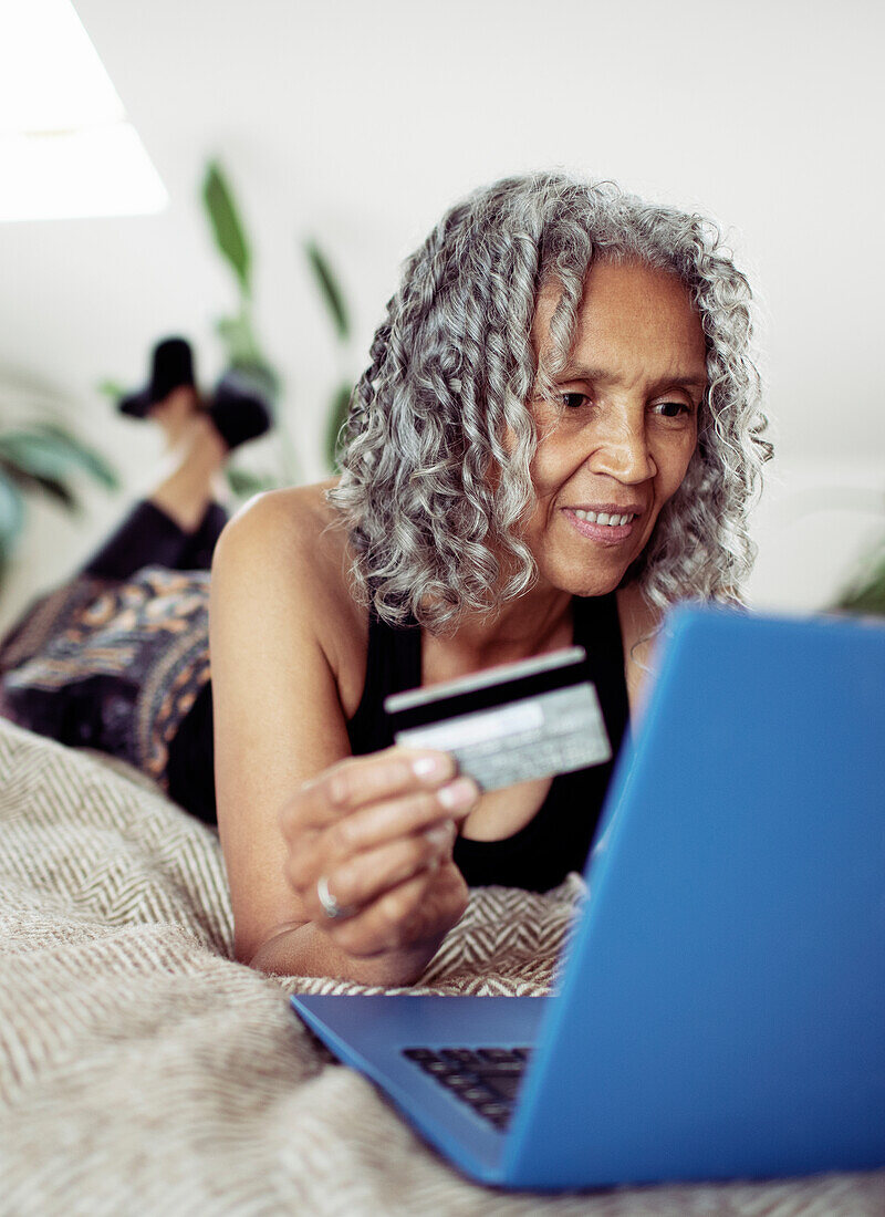 Woman with credit card online shopping at laptop