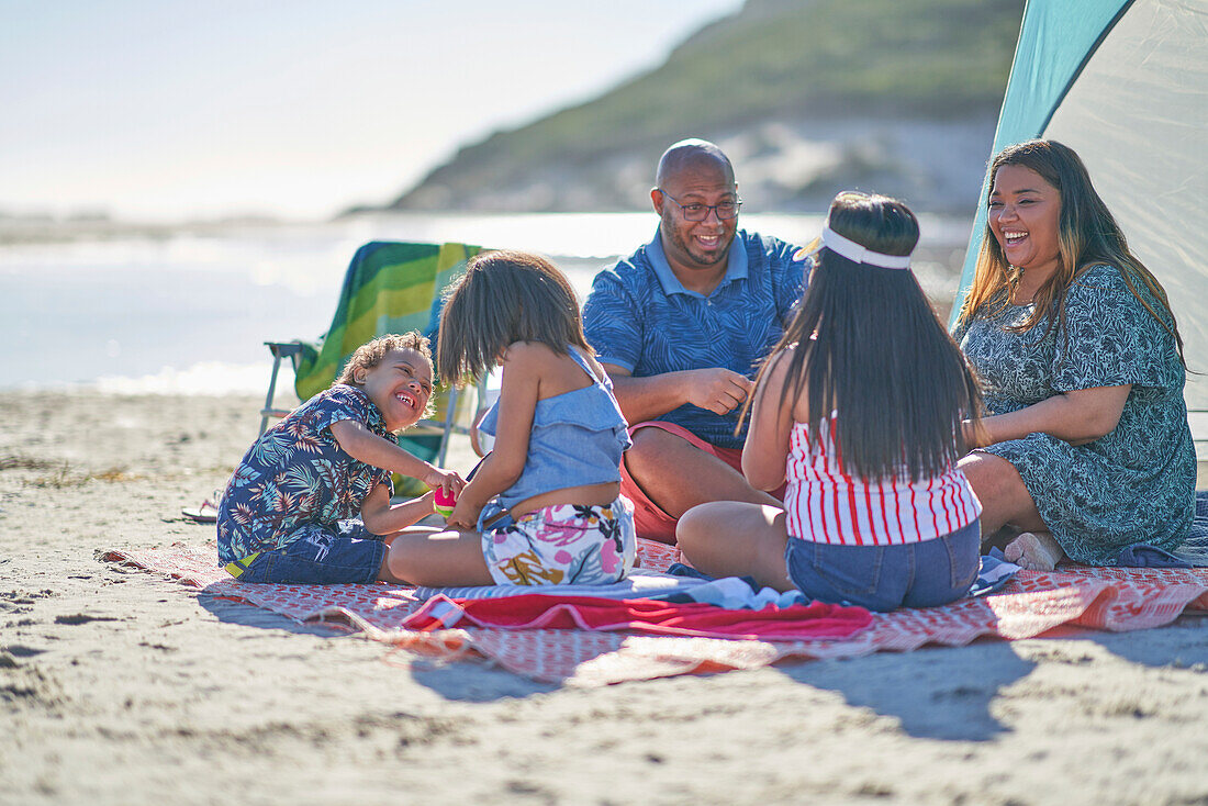 Happy family on picnic blanket at beach