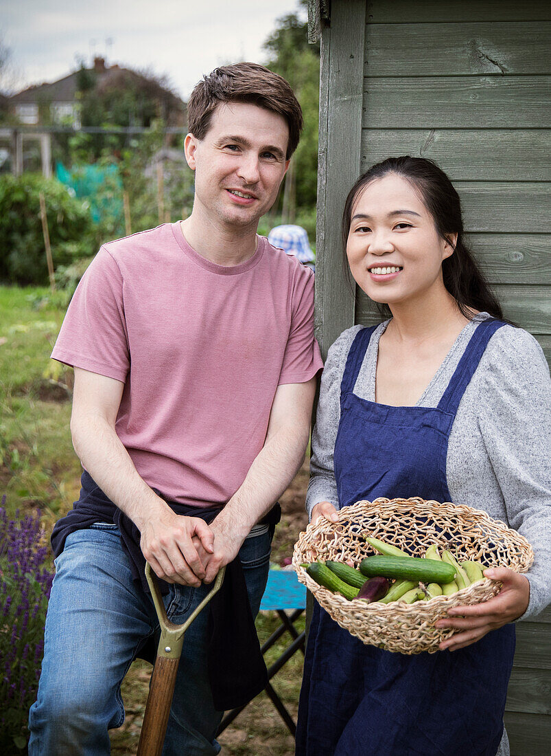 Happy couple harvesting fresh vegetables