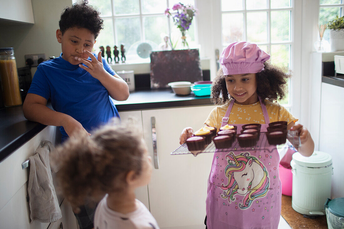 Kids baking cupcakes in kitchen