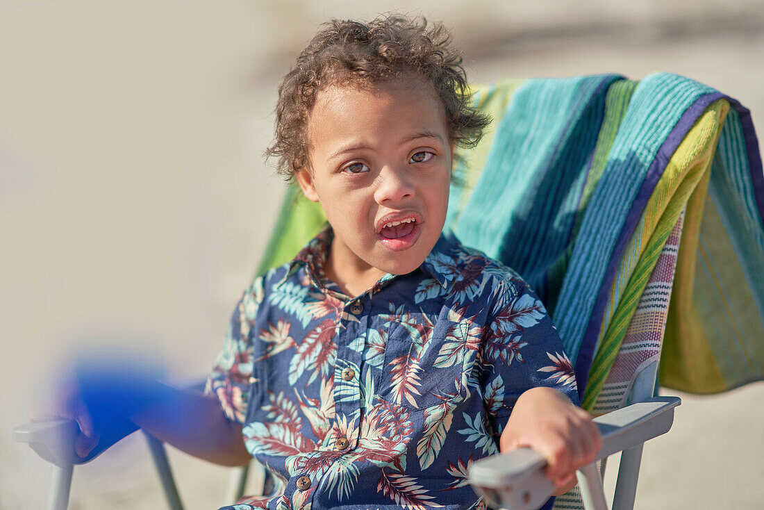Boy with Down Syndrome in beach chair
