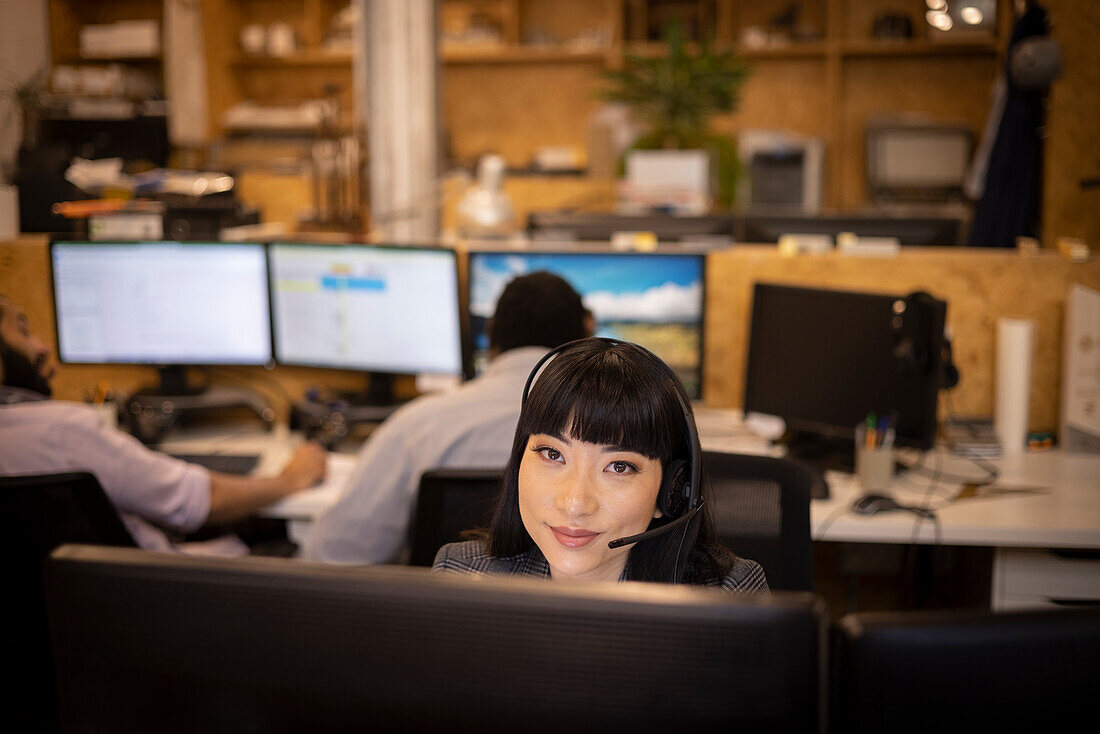 Smiling businesswoman with headset working in office