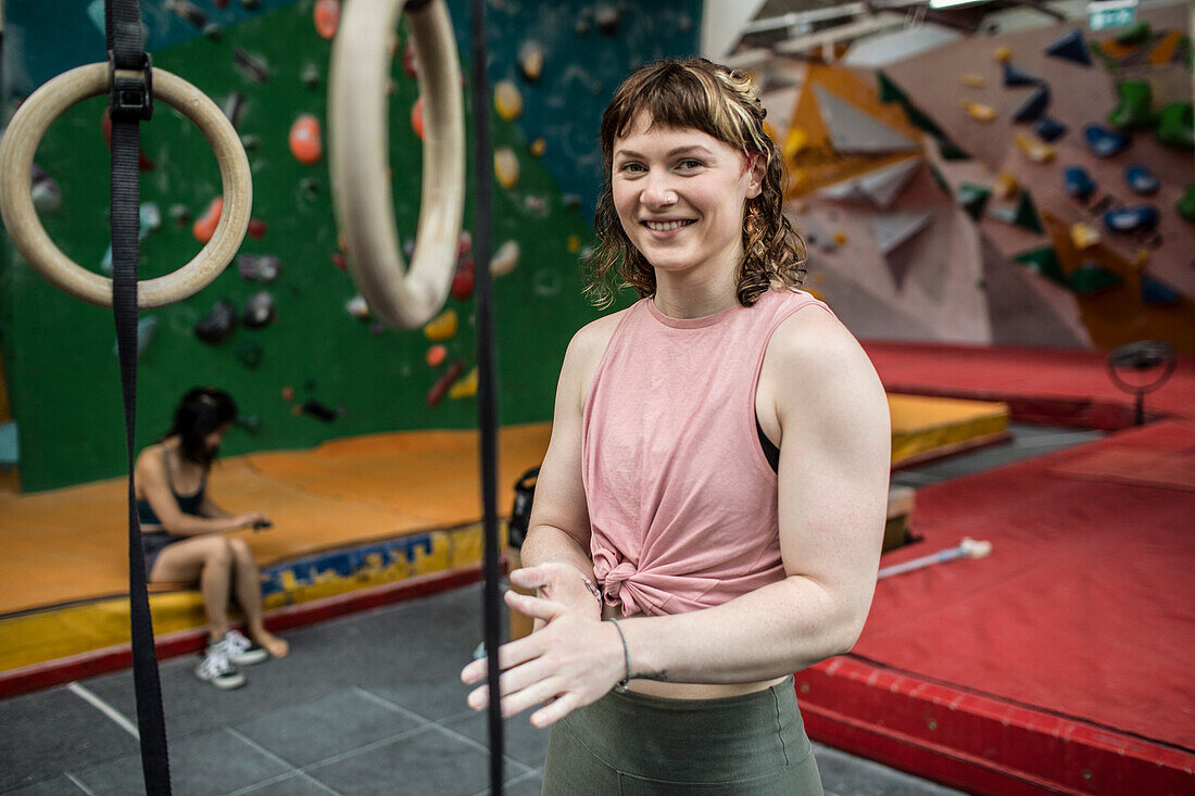 Young woman chalking hands at climbing center