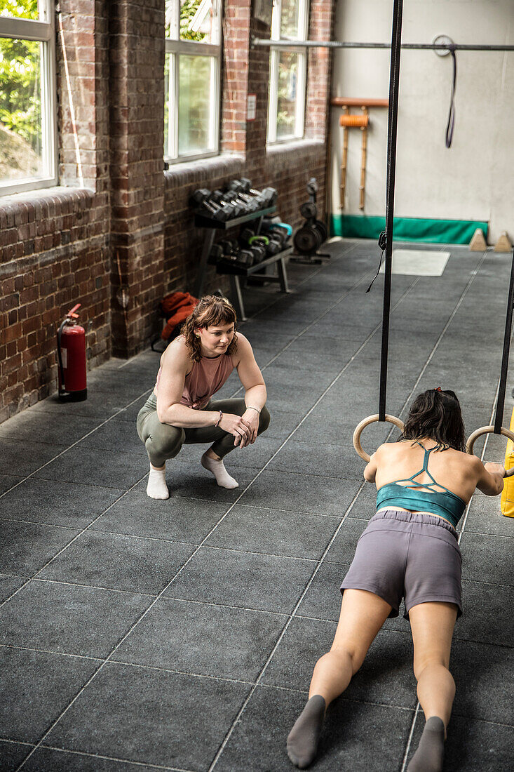 Personal trainer working with client in gym