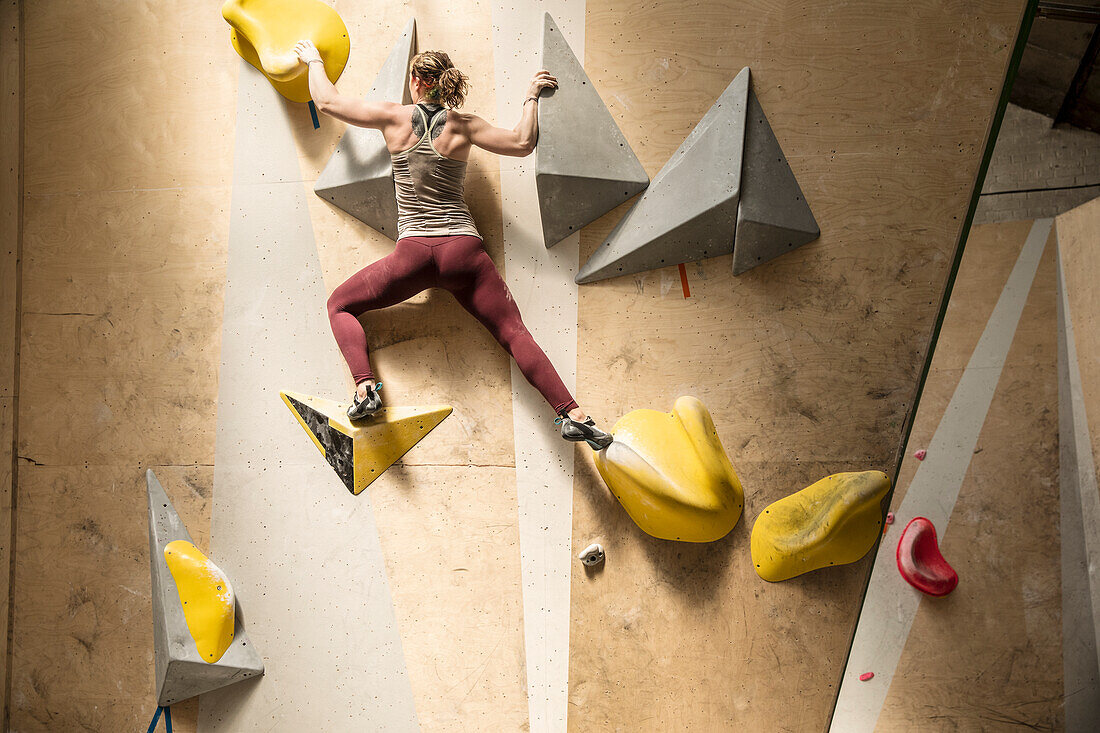 Young, strong woman on climbing wall