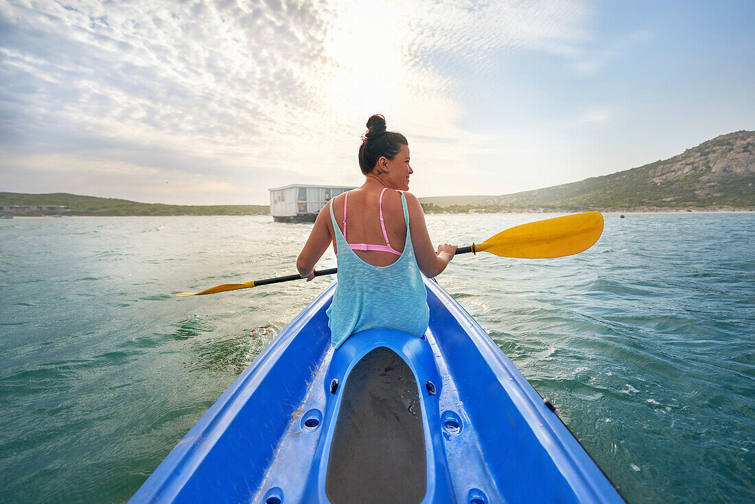 Woman with oar kayaking on sunny lake