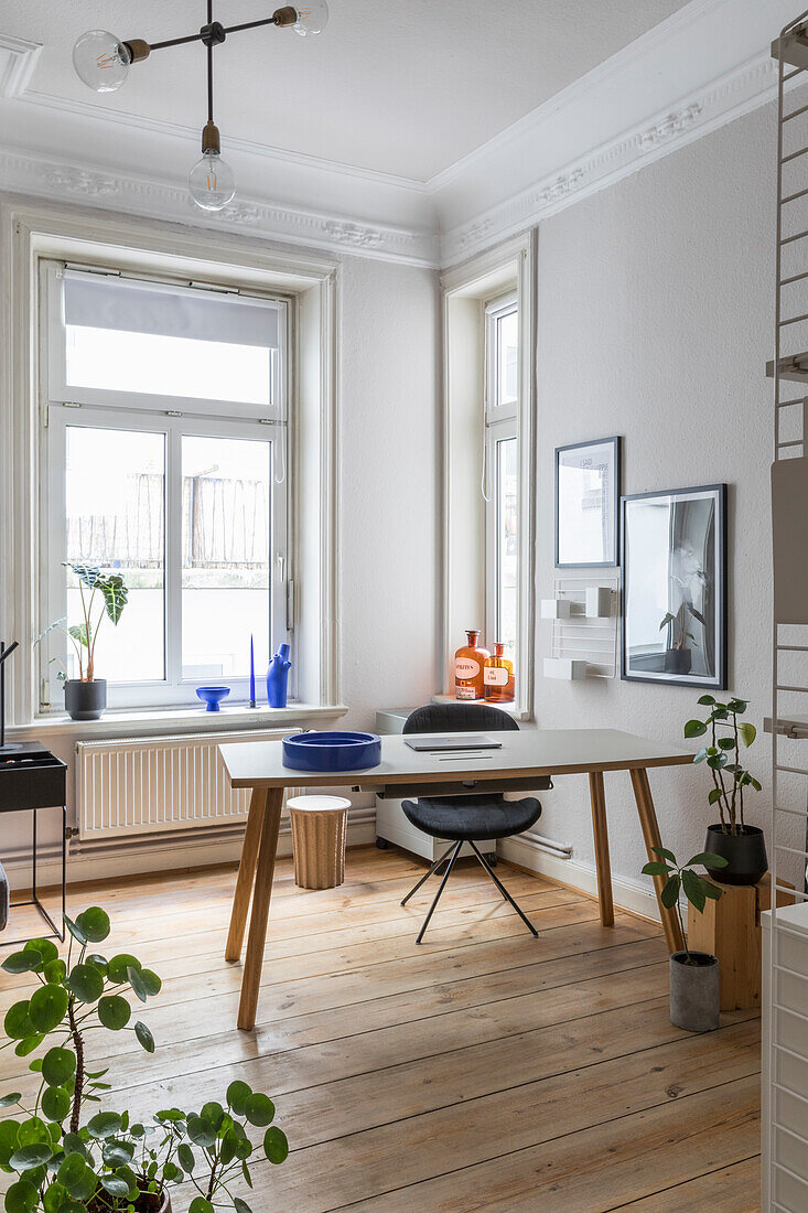 Schreibtisch mit Stuhl im Zimmer mit Dielenboden und Stuckdecke