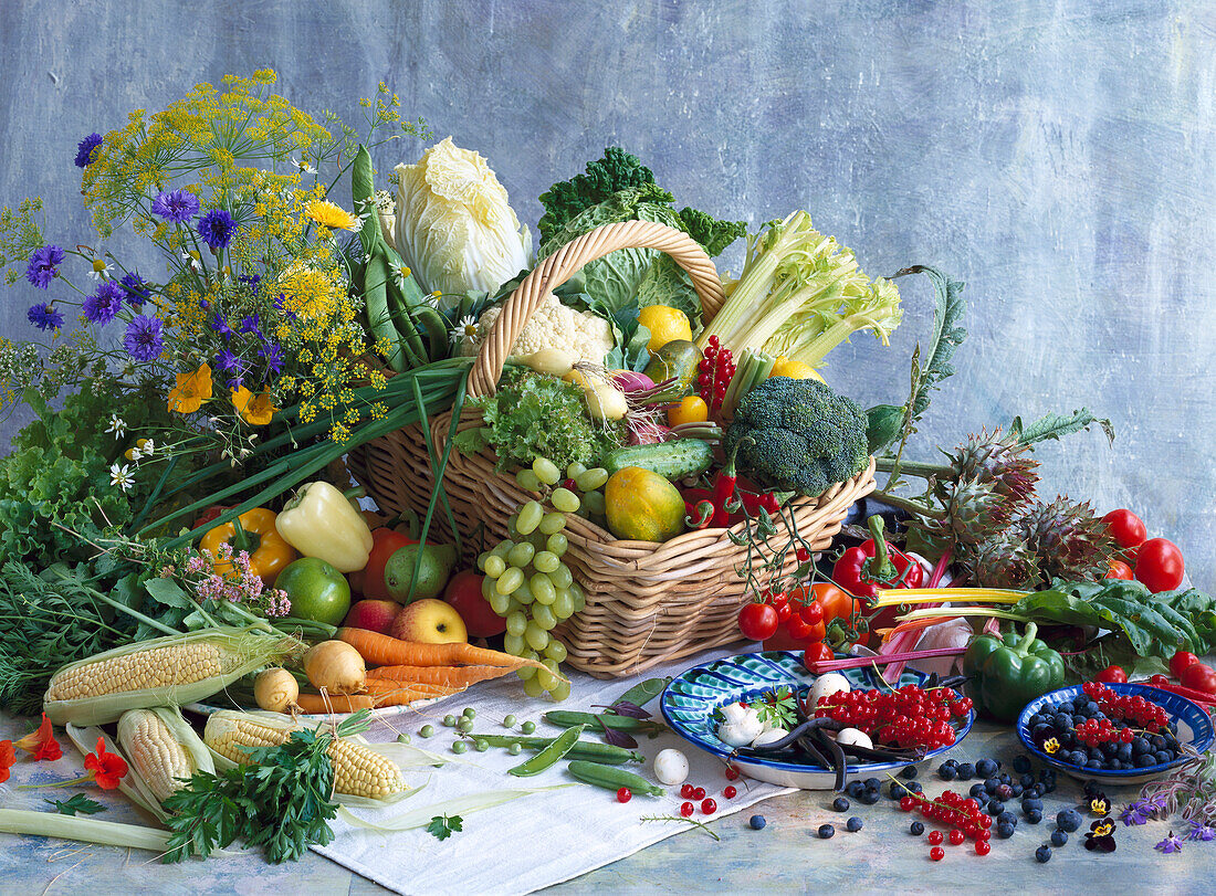 Different kinds of vegetables and fruits in and around a basket