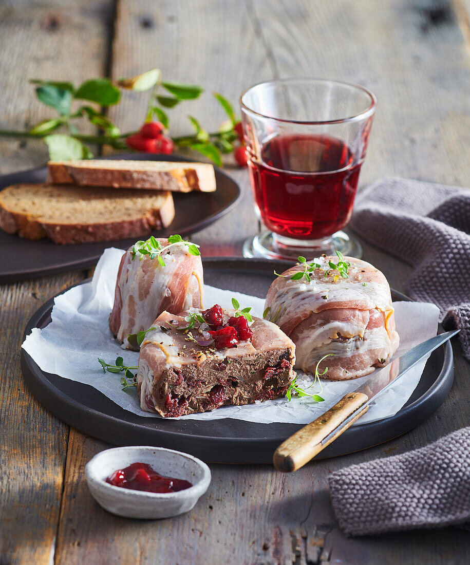 Game pâté wrapped in bacon with cranberries