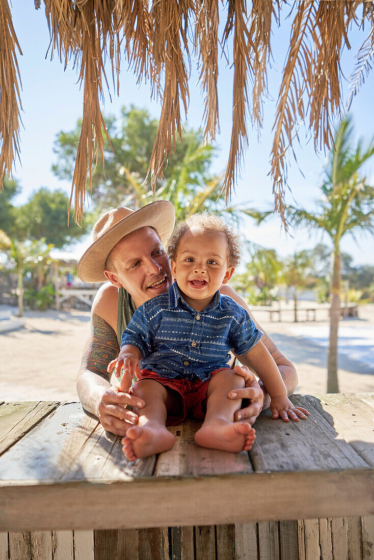 Happy father and toddler son at beach hut