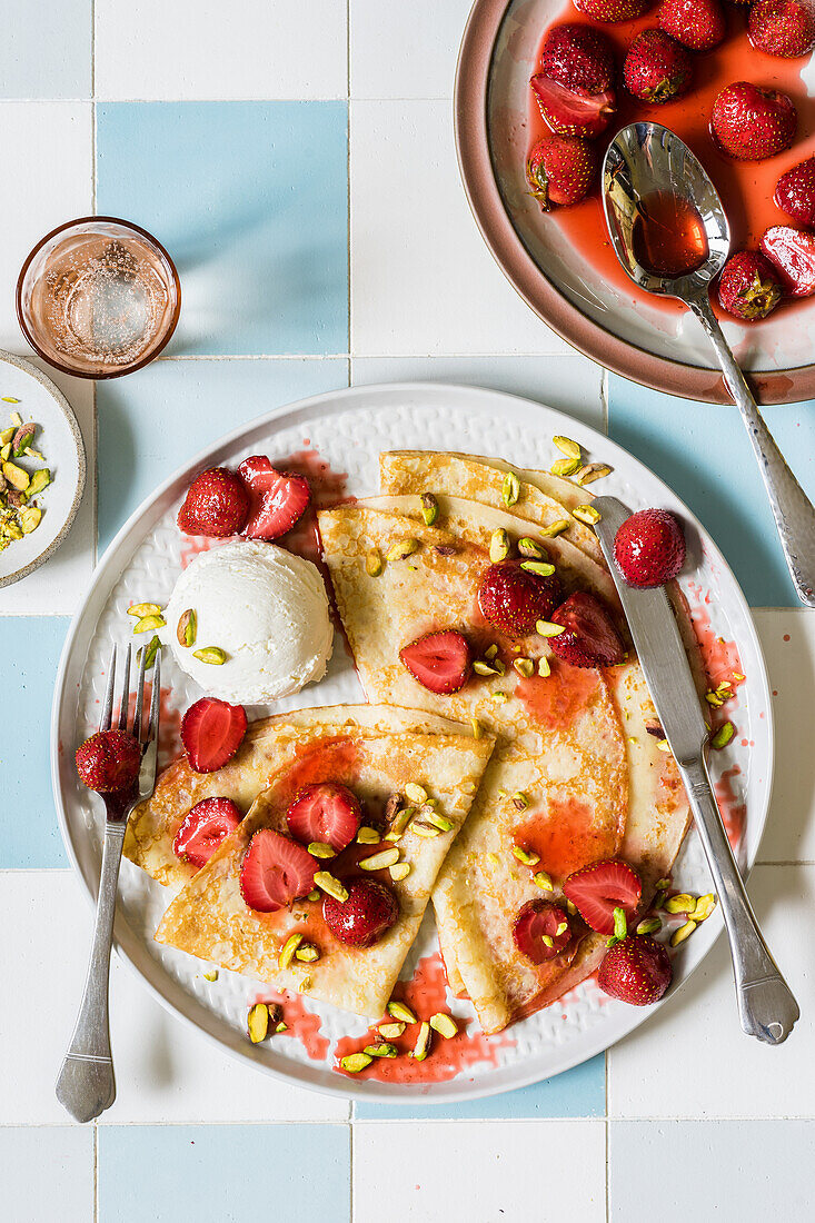 Thin crepes with honey roasted strawberries compote, pistachios and a scoop of cream cheese