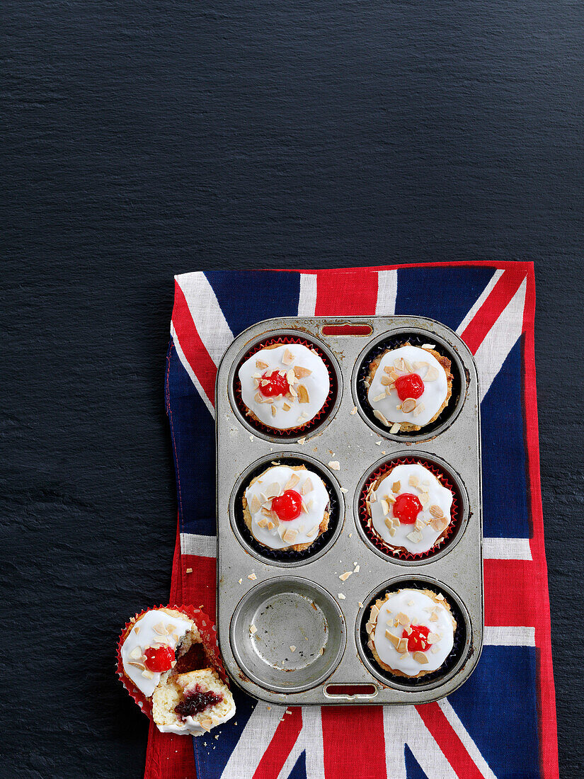 Cherry bakewell muffins in baking tray on British flag