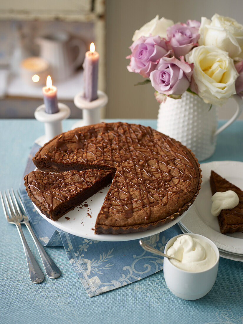 Chocolate tart with cream on a festive table setting