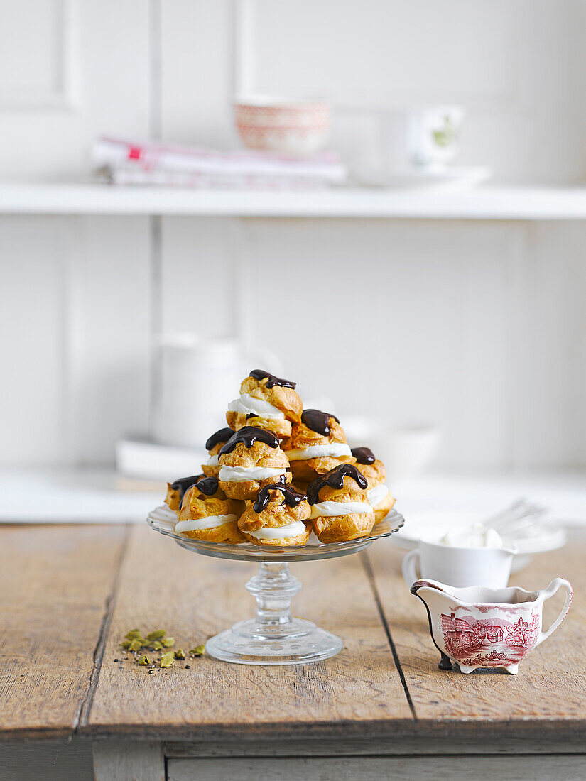 Cream puffs with chocolate icing on a kitchen table