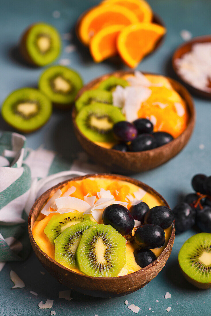 Mango-Smoothie Bowl mit Kiwi, Orangen, Trauben und Kokosnuss