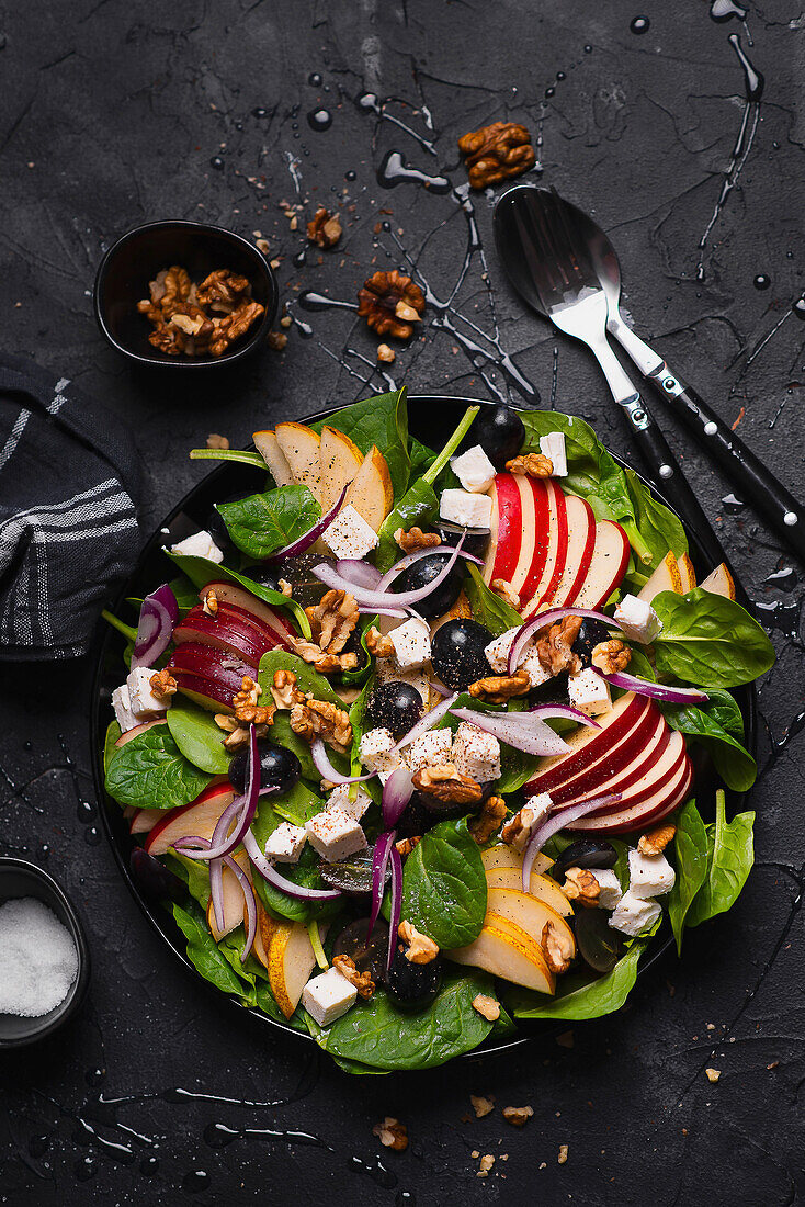 Spinach salad with apple, pear, grapes, feta cheese, and walnuts