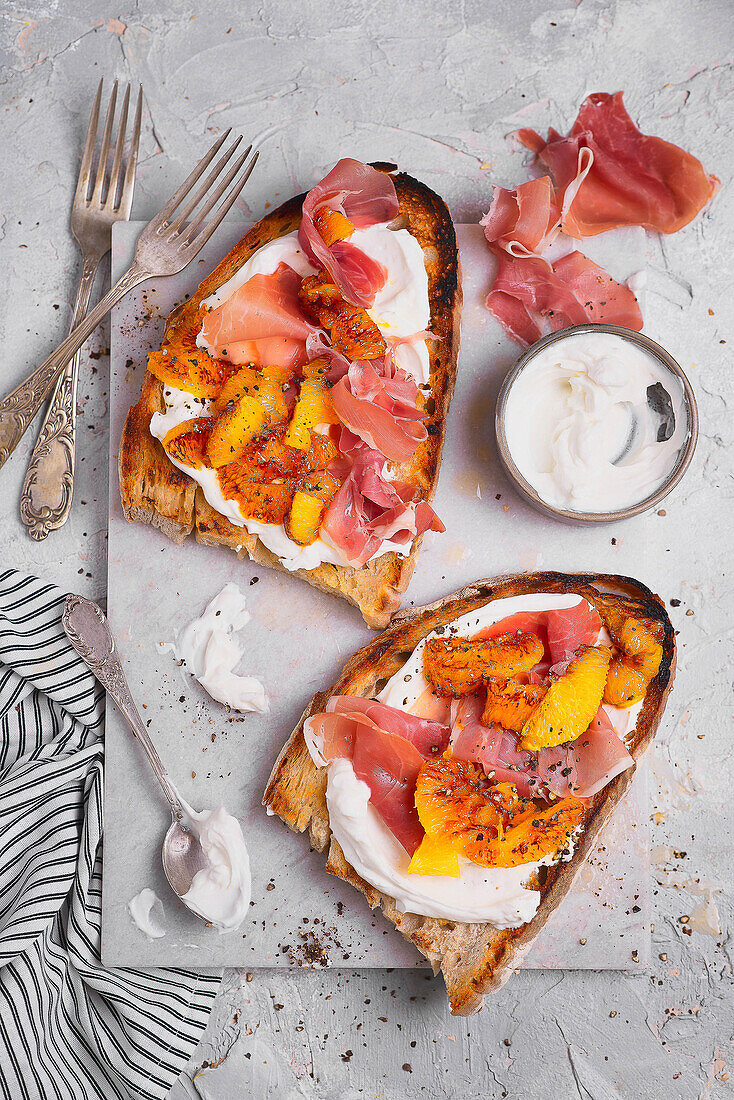 Röstbrot mit Frischkäse, Parmaschinken und karamellisierter Orange