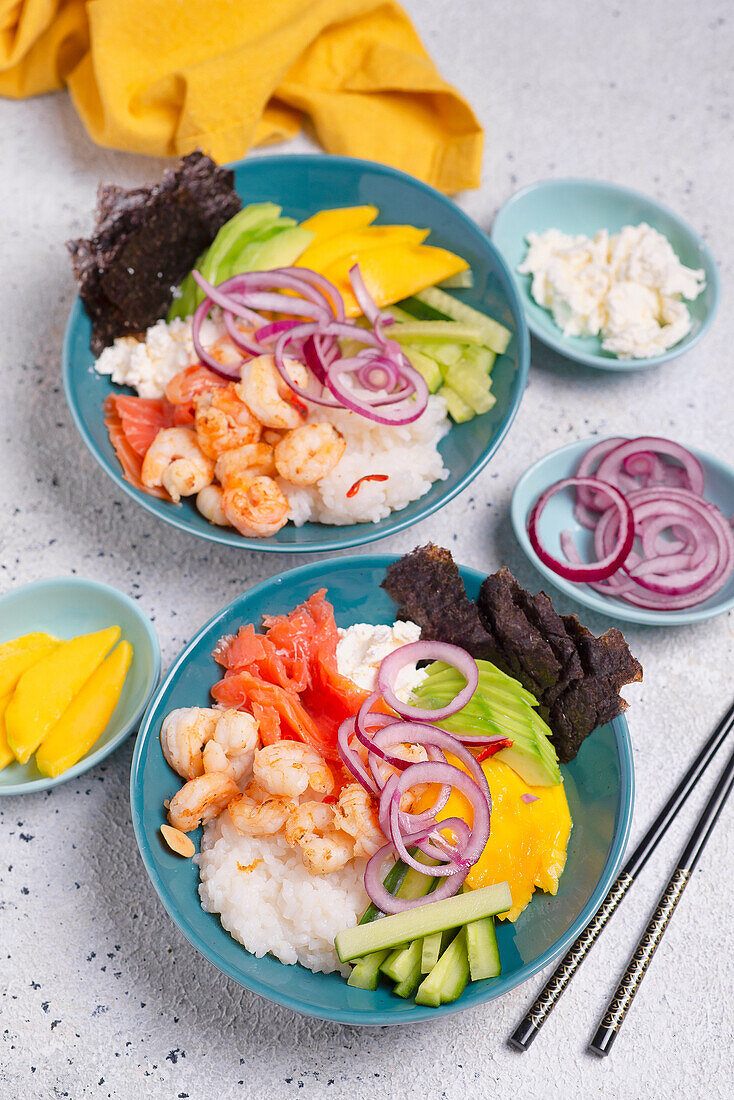 Sushi Bowl mit Reis, Lachs, Garnelen, Gurke, Nori, Mango, roter Zwiebel, Frischkäse