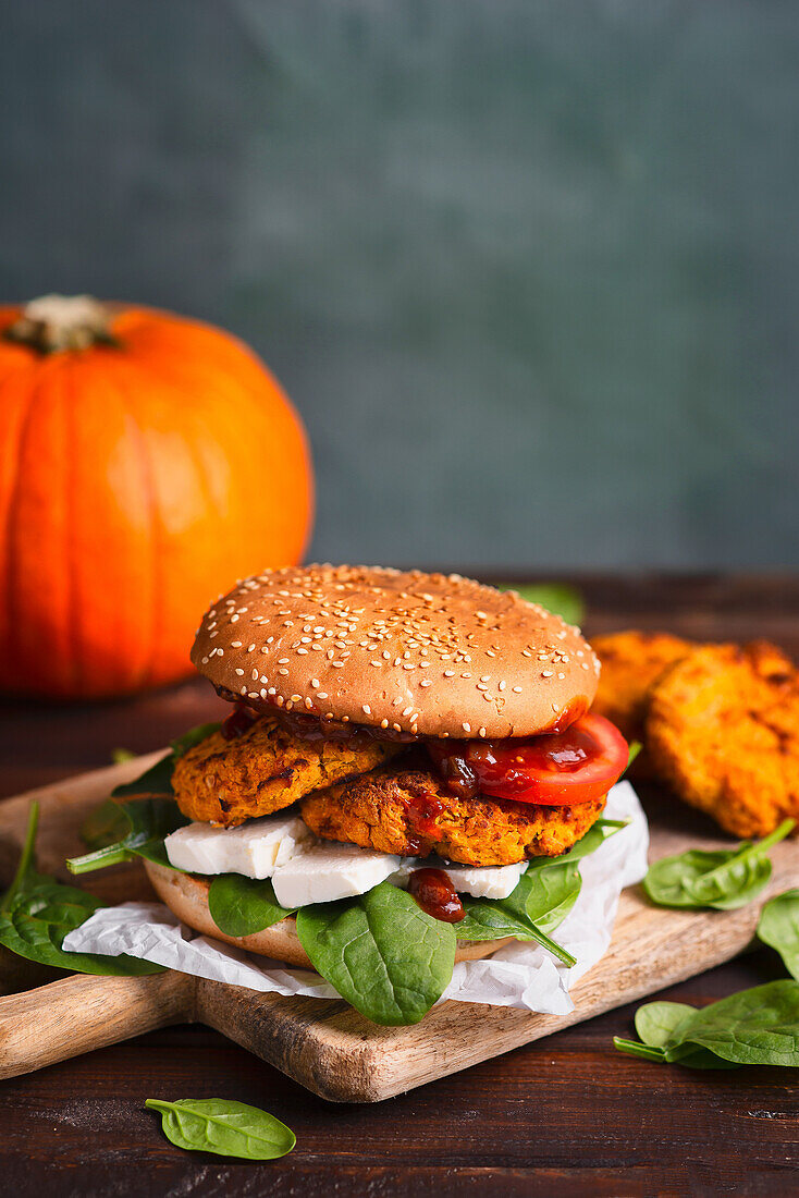 Burger mit Spinat, Feta-Käse, Kürbis-Schnitzel, Tomaten und Grillsauce