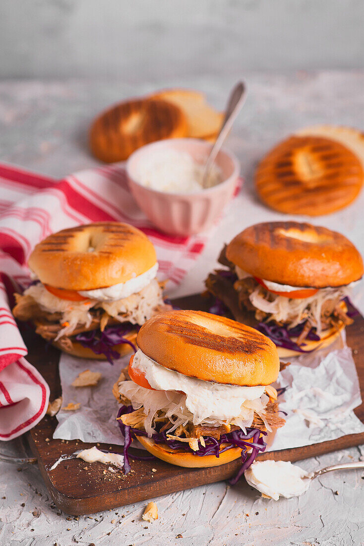 Burger mit Rotkohl, Pulled-Pork, Sauerkraut, Tomaten und Knoblauch-Sauce