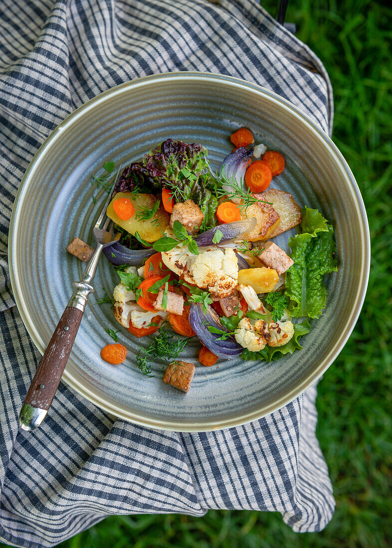 Colourful oven vegetables with fried tofu and garden herbs (vegan)