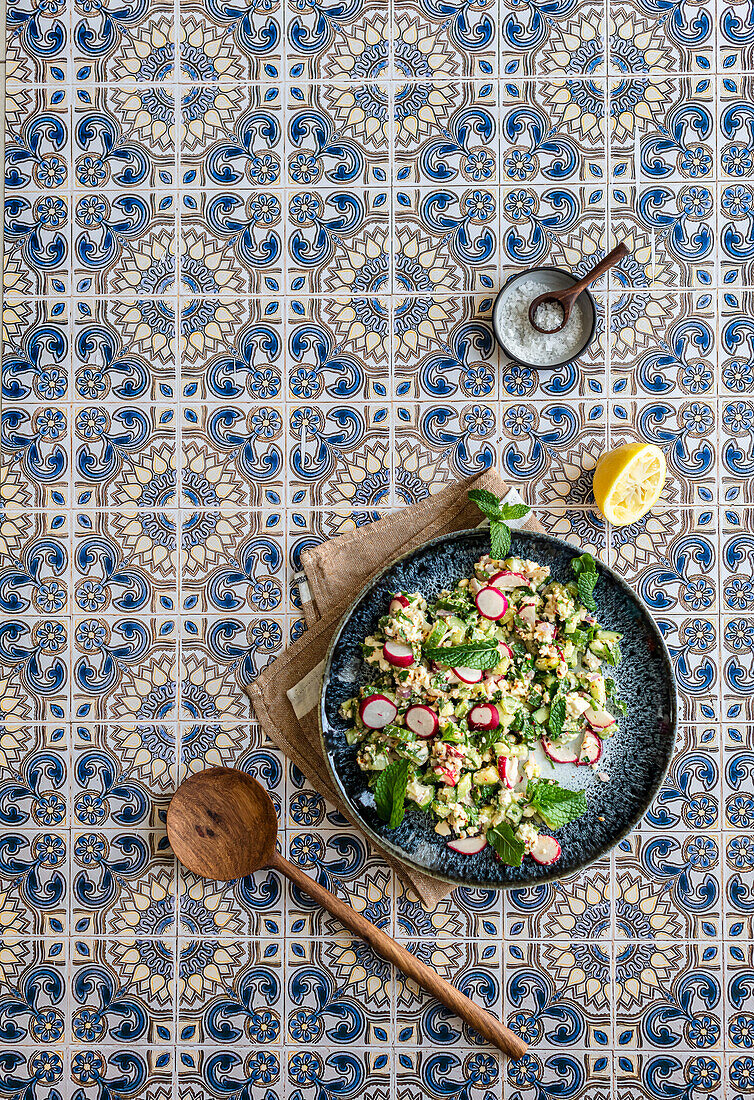 Gurkensalat mit Feta, Minze und Radieschen auf Fliesenuntergrund